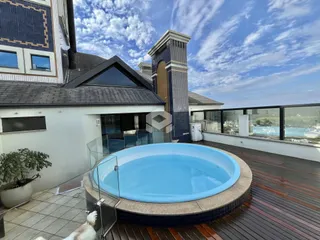 Vista externa de uma piscina e deck em uma residência.