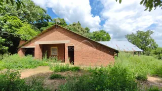 Fachada de uma casa de tijolos vermelhos em Lajeado, Brasil, cercada por vegetação densa.