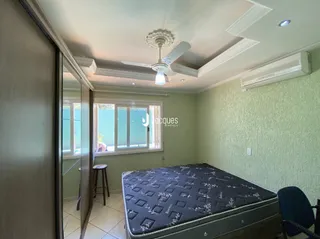Quarto com cama e janela em ambiente interno.
