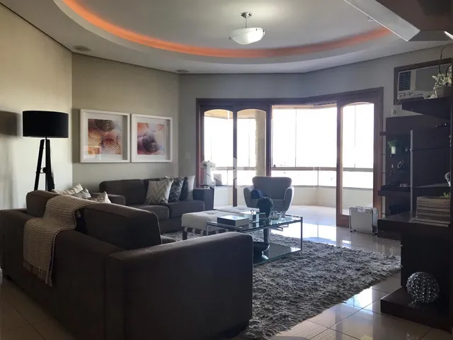 Sala de estar com sofá e portas de vidro que dão acesso ao exterior.
