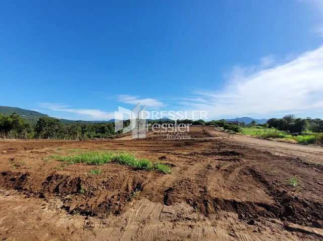 Imagem de terra arada e vegetação em área de terreno.