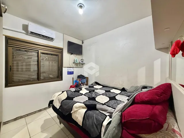 Quarto com cama e janela em um imóvel no Brasil.