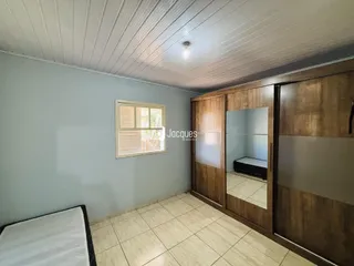Quarto com paredes azuis e piso de cerâmica em um imóvel no Brasil.