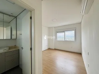 Interior de um apartamento mostrando uma passagem para um cômodo com janela.