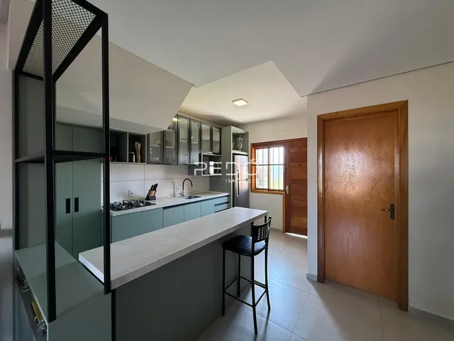 Vista da cozinha moderna com bancada e armários em Lajeado.