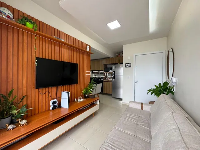 Sala de estar com parede de madeira e sofá em um apartamento.