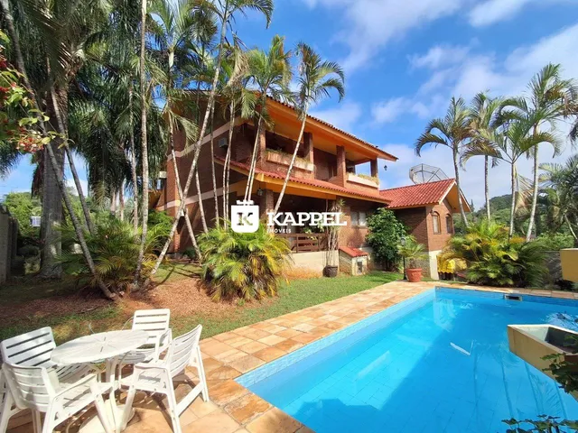 Foto da fachada de uma casa com piscina e área externa em Lajeado.