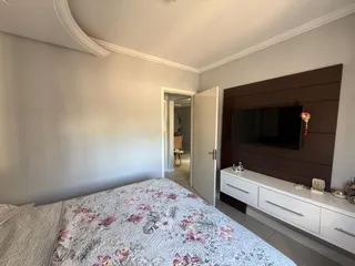 Foto de um quarto com cama e televisão em um ambiente interno.
