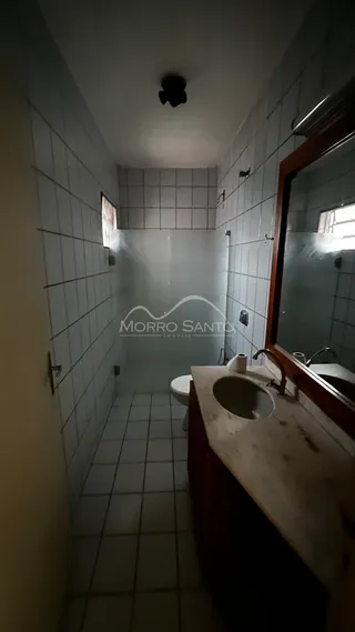 Corredor interno com piso e paredes revestidos de azulejos claros.