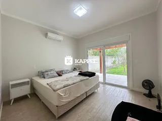 Quarto com cama grande e porta de vidro que dá acesso ao exterior.
