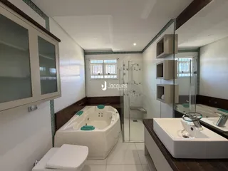Foto de um banheiro com banheira e box de vidro em um imóvel no Brasil.