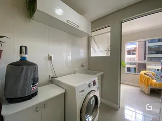 Foto de um banheiro com pia, vaso sanitário e máquina de lavar roupa.