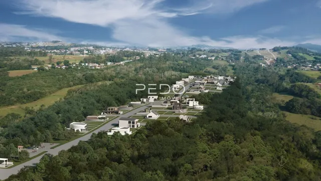 Vista aérea de uma área residencial em Lajeado, Brasil, mostrando casas e vegetação.