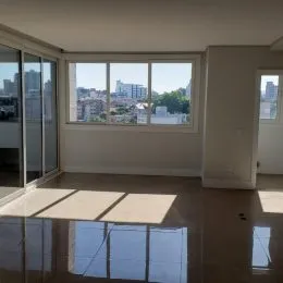 Ambiente interno com grandes janelas que oferecem vista para a cidade.