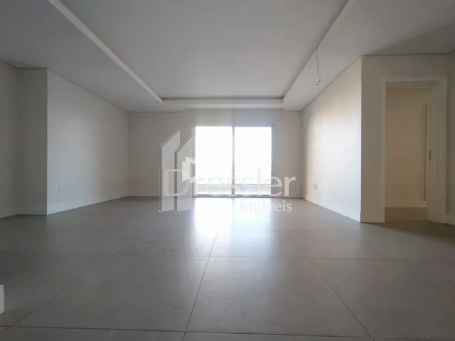 A sala é um espaço interno vazio com paredes brancas.