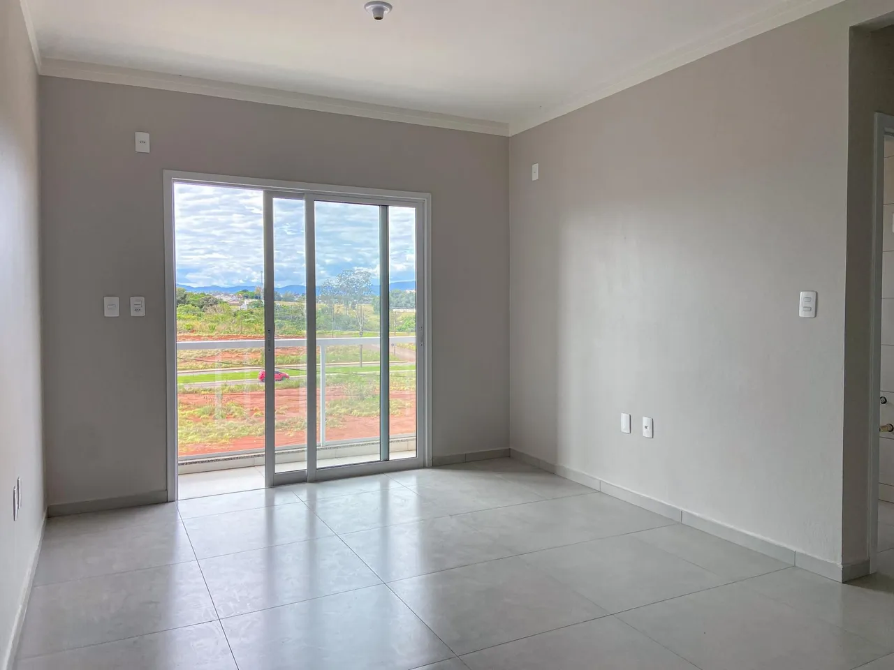 Sala de estar com porta de vidro que oferece uma vista para o exterior.