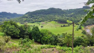 Vista panorâmica de colinas verdes e um vale com rio na paisagem.