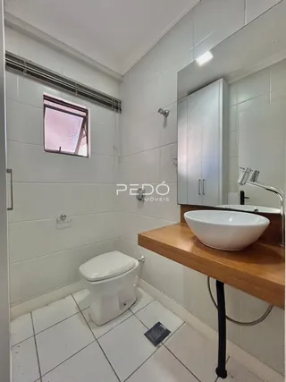 Foto de um banheiro com piso de cerâmica branca e azulejos brancos.