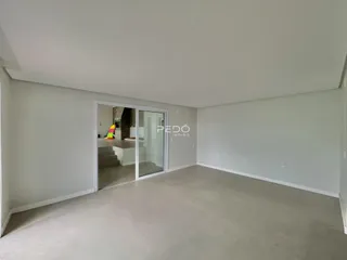 Vista interna de um ambiente com paredes brancas e piso claro.