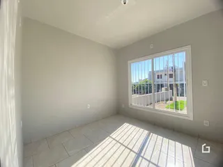 Ambiente interno de uma sala com piso de cerâmica e grande janela.