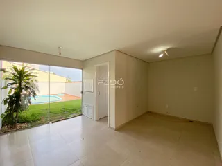 Ambiente interno com piso de cerâmica e porta de vidro abrindo para o quintal.