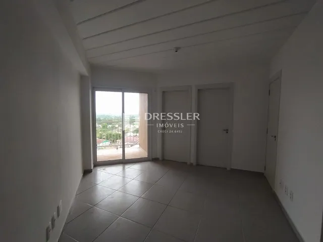 Interior de um corredor com piso de cerâmica e paredes brancas.
