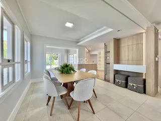 Vista de uma sala de jantar com mesa de madeira e cadeiras em um imóvel em Lajeado.