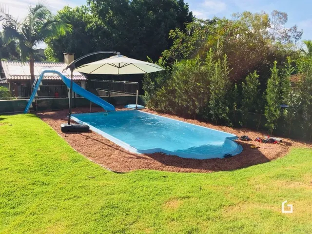 Piscina externa com área gramada ao redor.