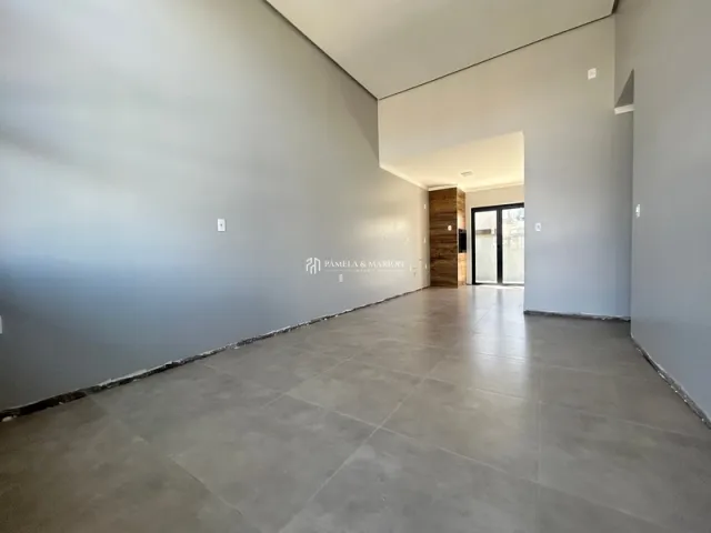 Foto de um corredor interno com paredes cinzas e piso claro.
