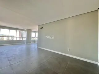 Sala ampla com piso de concreto e grandes janelas.