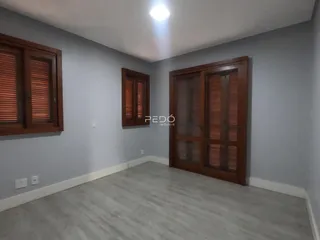 Interior de uma sala com paredes cinzas e portas de madeira.