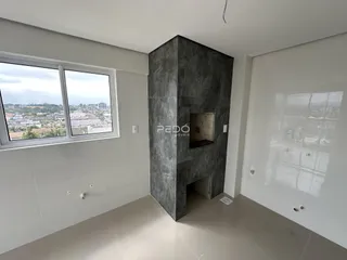 Ambiente interno com paredes brancas e uma grande estrutura de pedra escura.