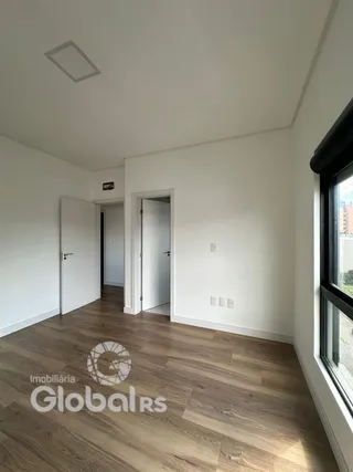 Interior de um ambiente com piso de madeira e paredes brancas.