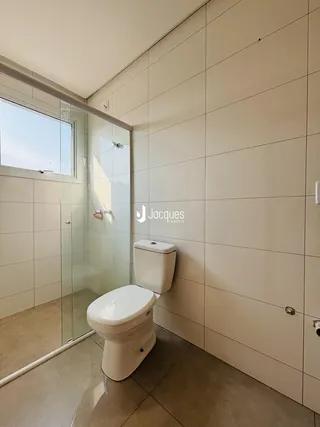 Foto de um banheiro com piso e paredes brancas e azulejos.