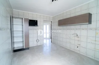 Corredor interno com paredes de azulejo claro e piso de cerâmica.