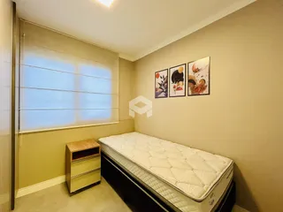 Quarto com cama e janela em ambiente interno.