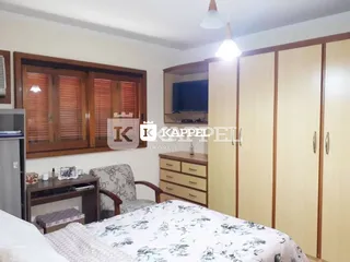 Quarto com cama e armários de madeira em um imóvel.