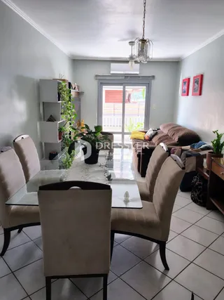 Uma sala de estar com móveis e piso cerâmico.