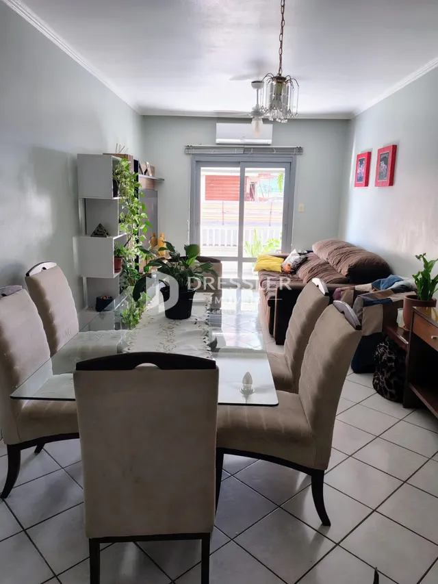 Uma sala de estar com móveis e piso cerâmico.