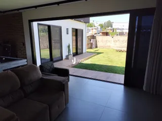 Vista da sala de estar com acesso ao quintal através de portas de vidro.