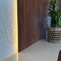 Detalhe de parede de madeira escura em um ambiente interno.