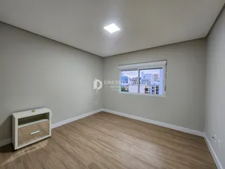 Foto de um cômodo interno com piso de madeira clara e janela.