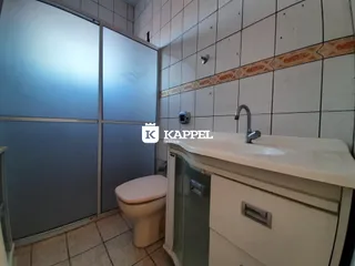 Foto de um banheiro interno com azulejos e um lavatório branco.