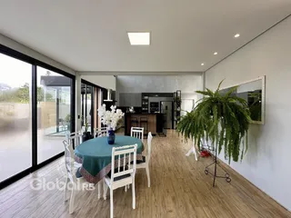 Sala de jantar com piso de madeira e portas de vidro que dão para o exterior.