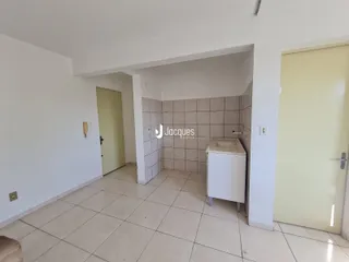Hall de entrada com acesso a um banheiro revestido de azulejos.