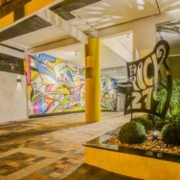 Interior de uma área comum com piso de madeira e parede decorada em Lajeado.