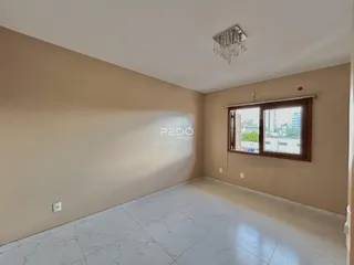 Vista interna de uma sala com piso de cerâmica e janela.
