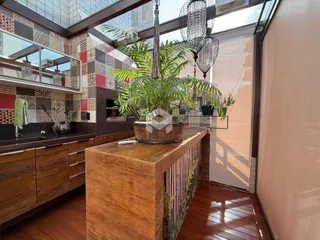 Ambiente interno com piso de madeira e grandes janelas na sala.