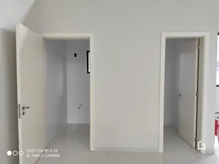 Hall de entrada com portas brancas em uma residência.