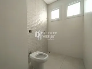 Foto interna de um banheiro com paredes brancas e azulejos brancos.